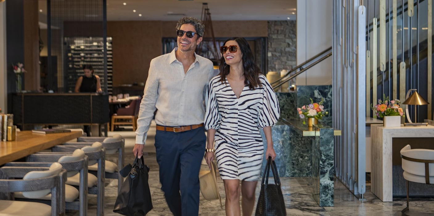Happy couple leaving Clio Hotel restaurant; Cherful man and woman leaving hotel restaurant