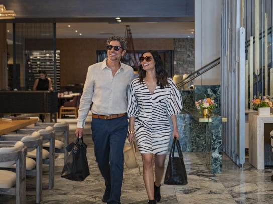 Happy couple leaving Clio Hotel restaurant; Cherful man and woman leaving hotel restaurant