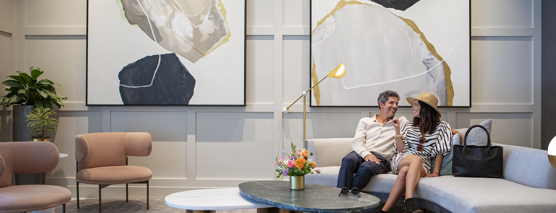 Couple sitting at Clio's Hotel lounge; Man and woman sitting at a gray couch at a Clio's Hotel lounge.