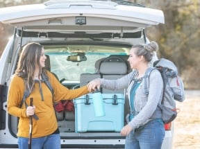 two women beside an SUV
