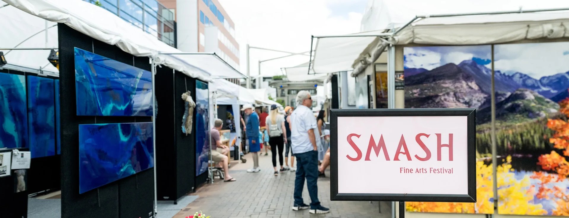 long walkway of popup tents showing off art at the SMASH fine arts festival