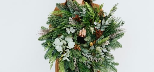 a woman holding a wreath she made at Hotel Clio