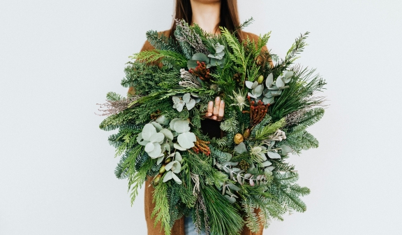 a woman holding a wreath she made at Hotel Clio