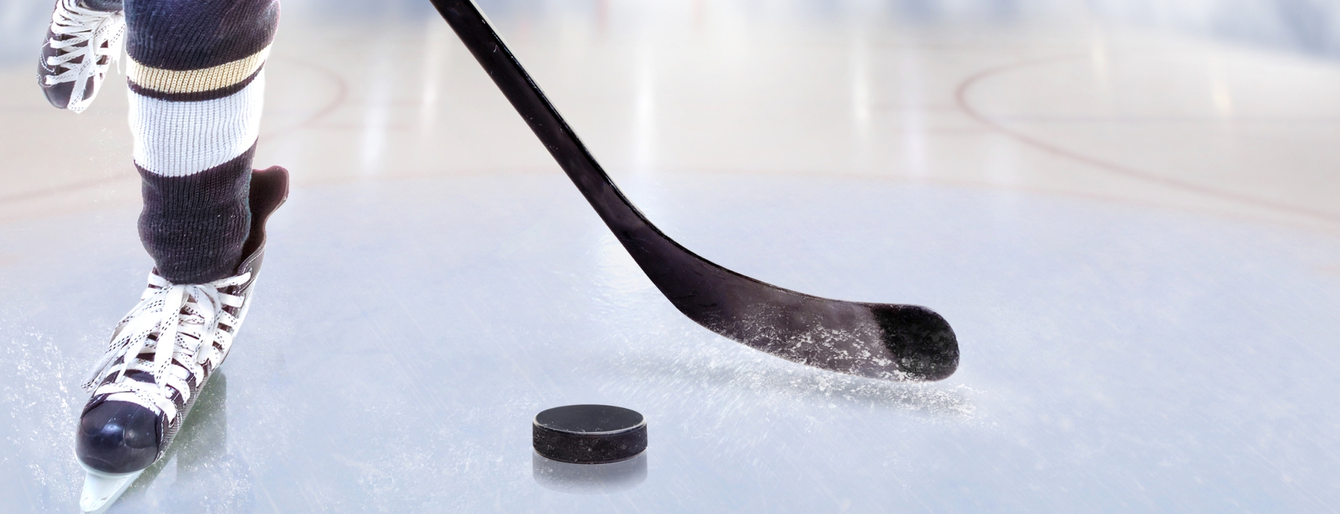 close up of a hockey player skating with their stick and puck
