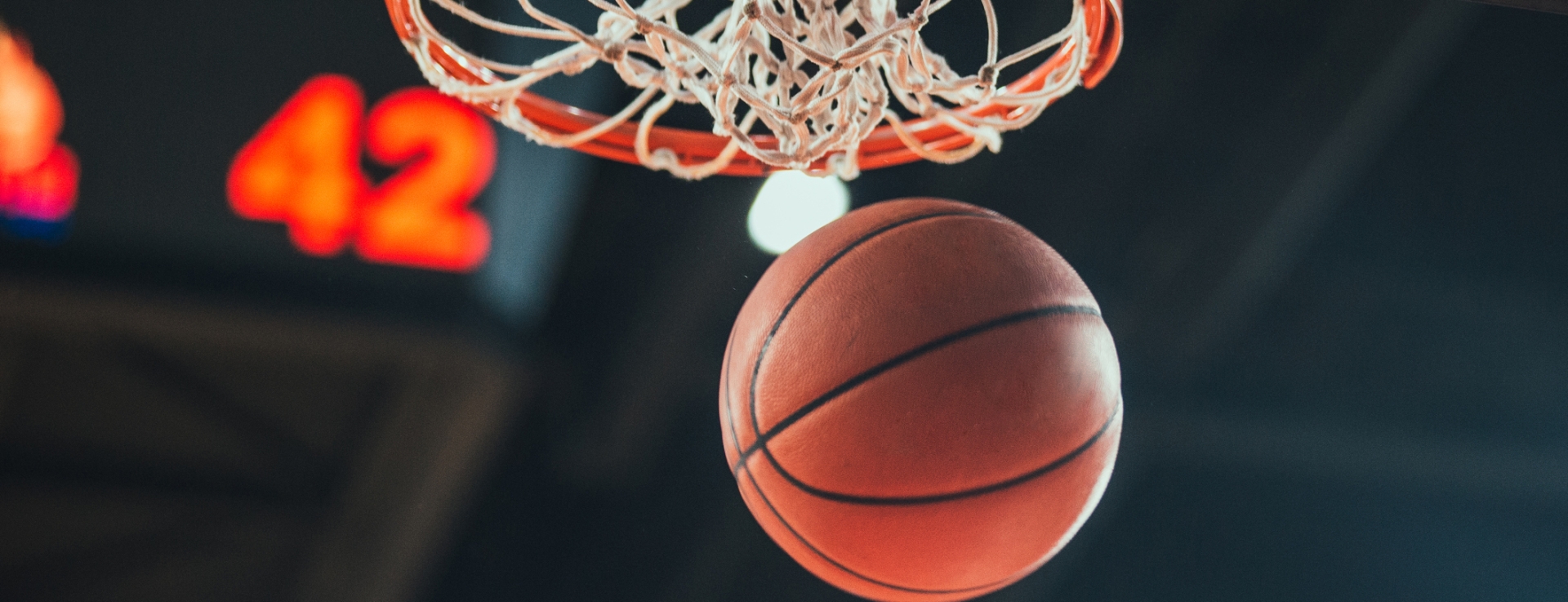 a basket ball falling to the ground after going through the hoop