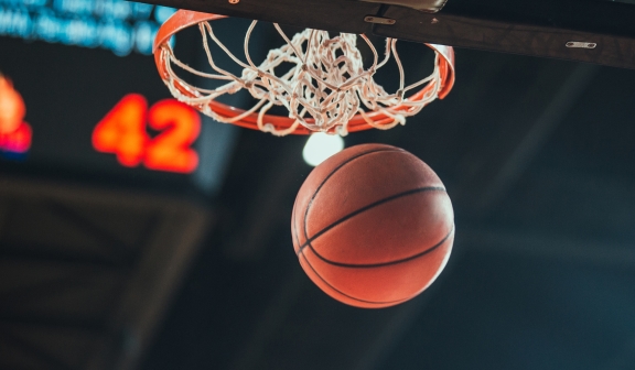 a basket ball falling to the ground after going through the hoop