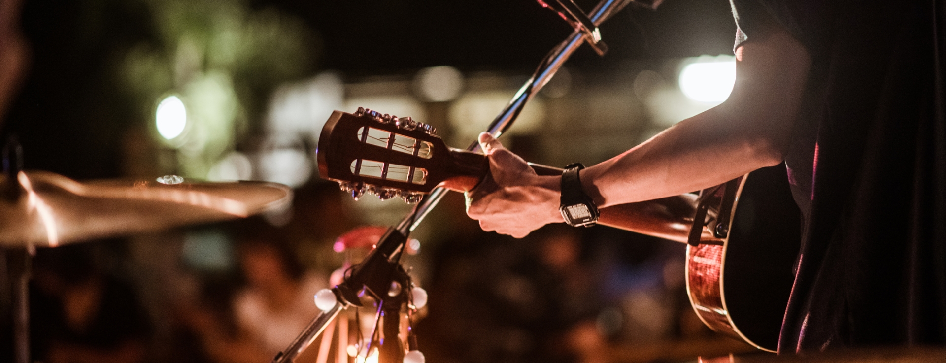 a person play guitar and singing on a stage