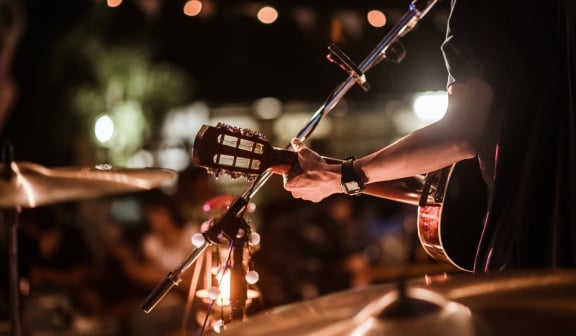 a person play guitar and singing on a stage