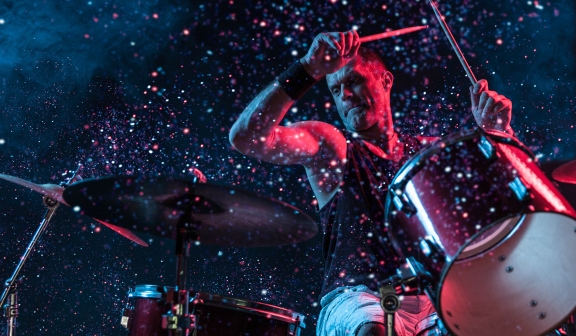 a drummer playing his drums and sparkles in the background