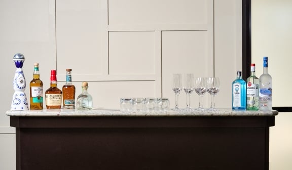 A close up of a open bar with bottles of alcohol and glasses