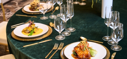 Plates of food on a large round table set up for dinner service at Hotel Clio