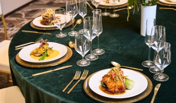 Plates of food on a large round table set up for dinner service at Hotel Clio