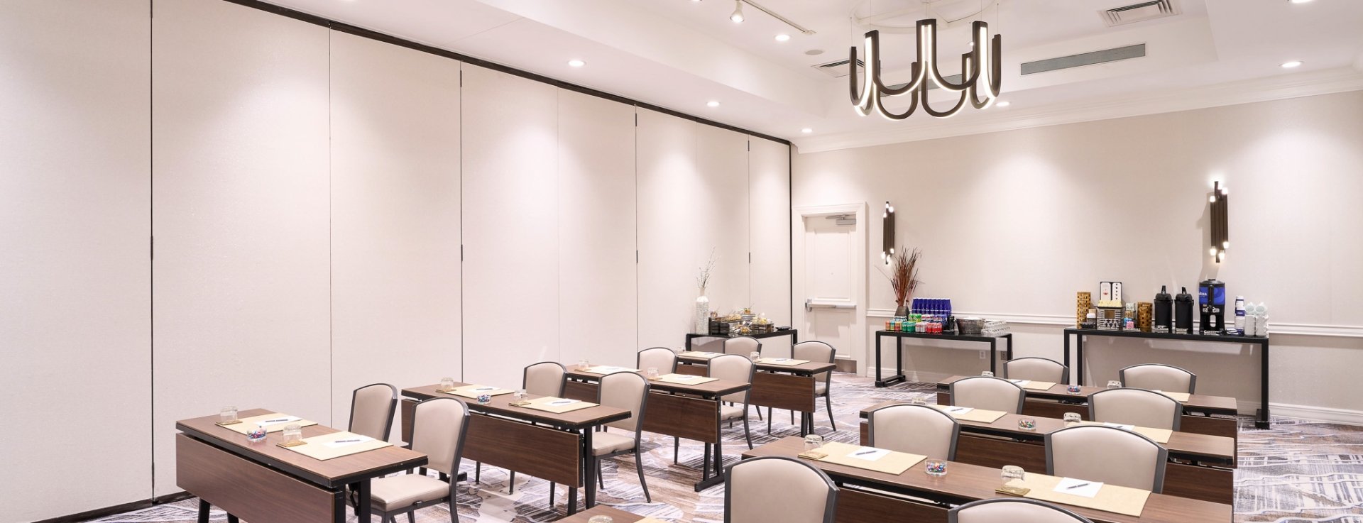 Meeting room at Hotel Clio with multiple rows of desks and chairs ready for a business meeting