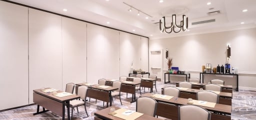 Meeting room at Hotel Clio with multiple rows of desks and chairs ready for a business meeting