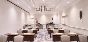 Meeting room with multiple tables and chairs along with a refreshment bar in the back at Hotel Clio