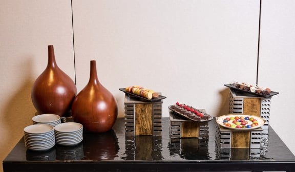 Table prepared with desserts and plates for guests at Hotel Clio