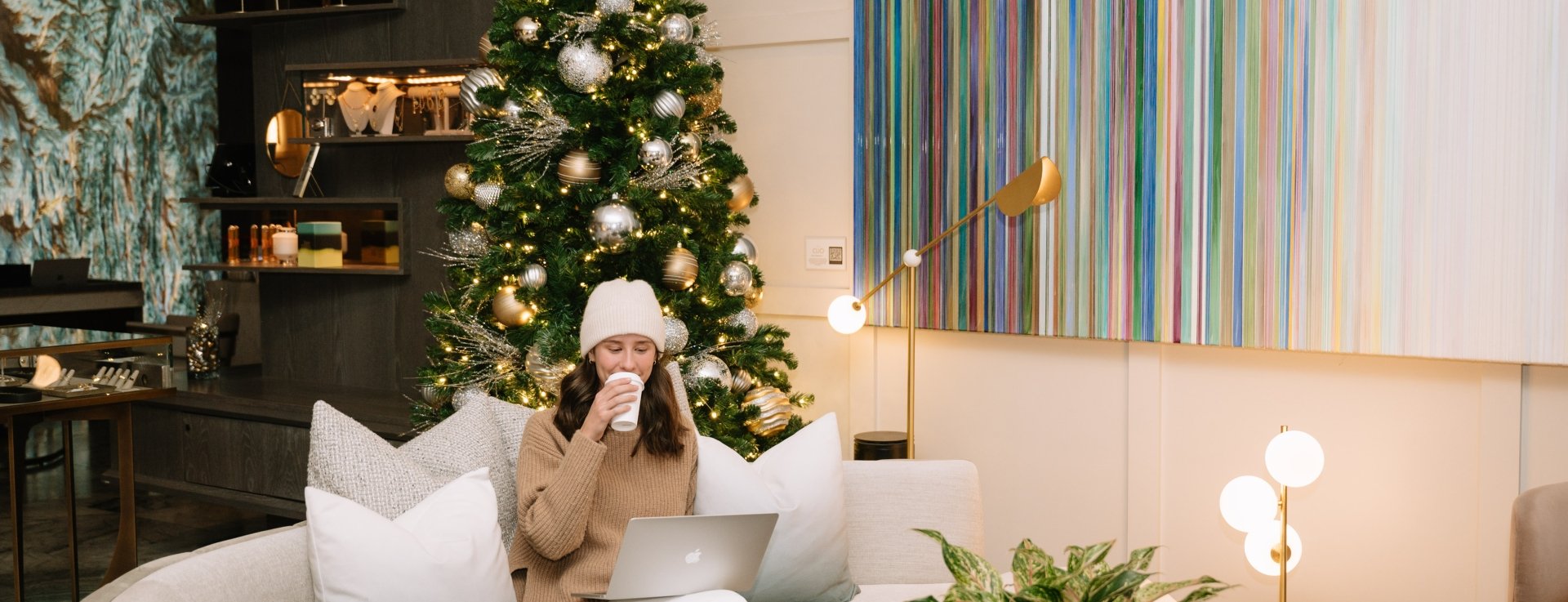 a woman enjoying a drink while sitting in a common area inside Hotel Clio