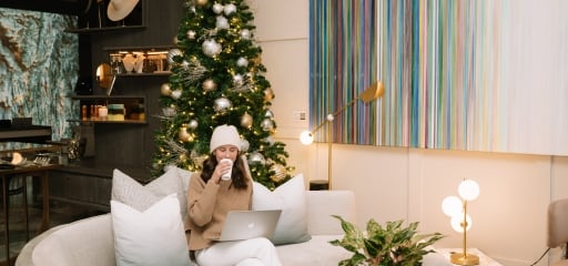 a woman enjoying a drink while sitting in a common area inside Hotel Clio